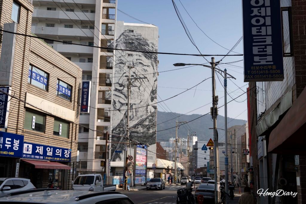 Vista de calle con mural de gran formato en el Pueblo de Arte Ganggangyi, Yeongdo Busan
