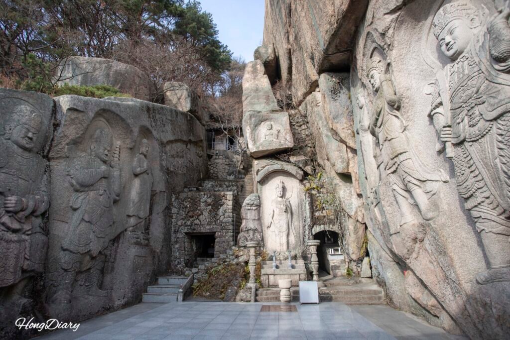 Stone Buddha figures carved into the cliff face at Seokbulsa Temple, Busan