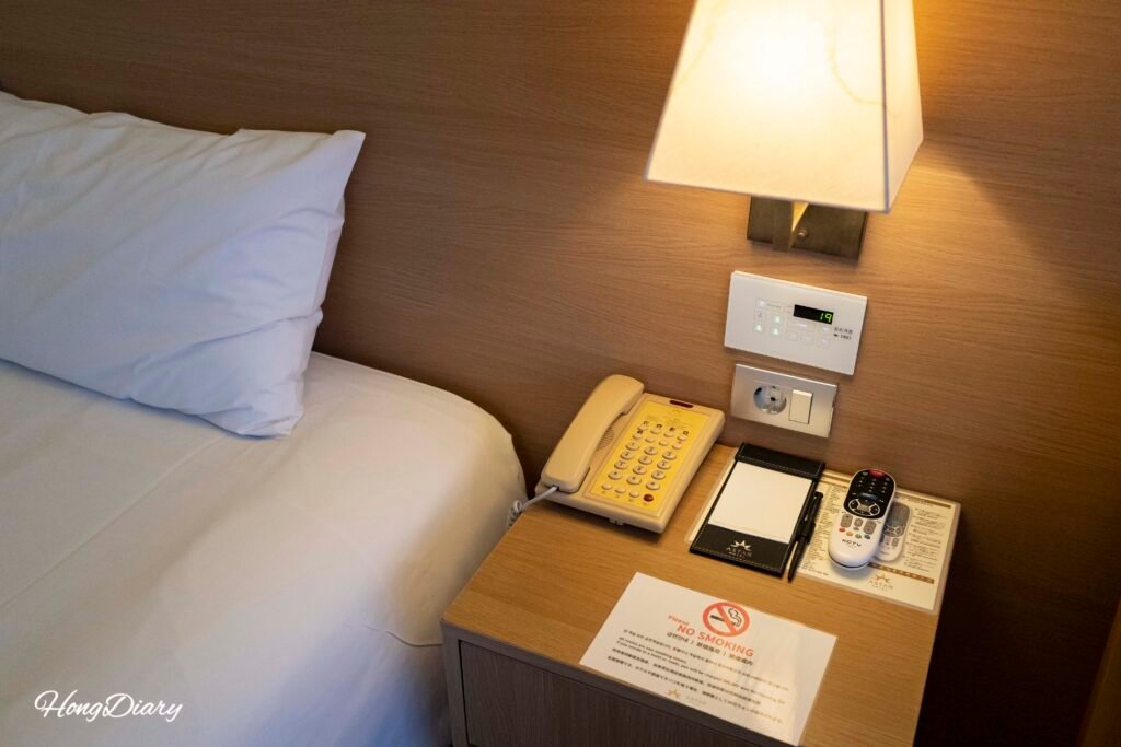 Bedside table and phone in Astar Hotel guest room, Jeju