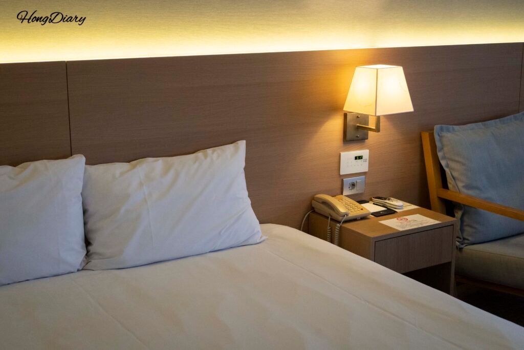 Cama y mesa de noche en Astar Hotel, Jeju
