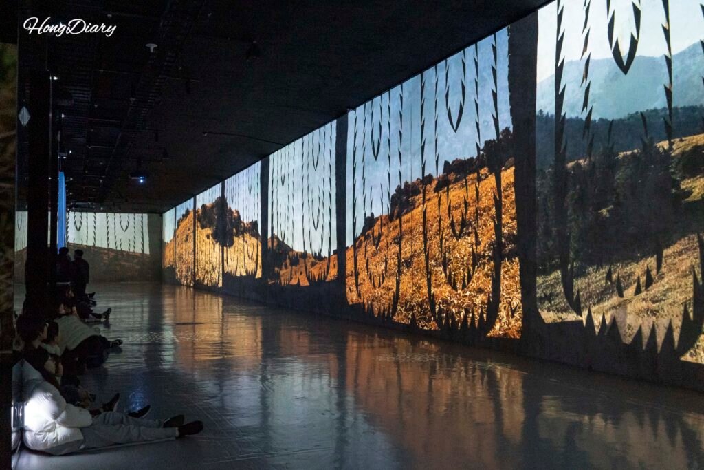 Exhibición inmersiva principal dentro del Bunker des Lumieres Jeju con proyecciones en paredes y suelo