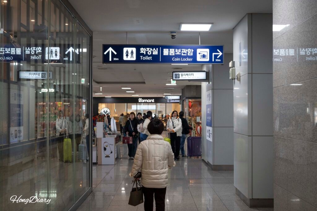 Directional signs inside Busan Station pointing toward coin locker luggage storage area
