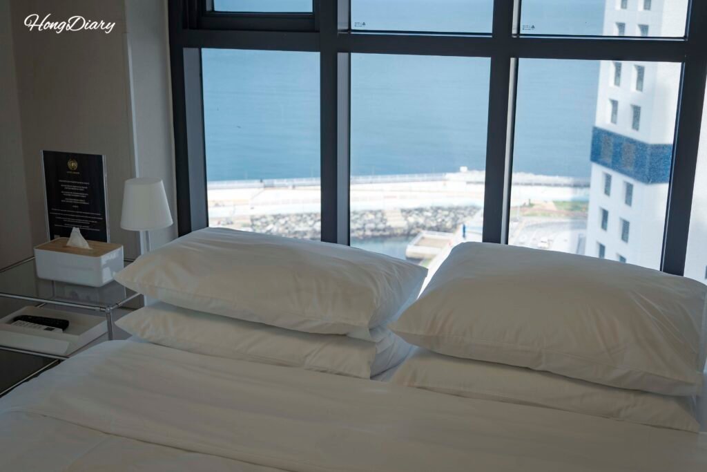 Cama y vista al mar del Grazie Hotel Busan Yeongdo