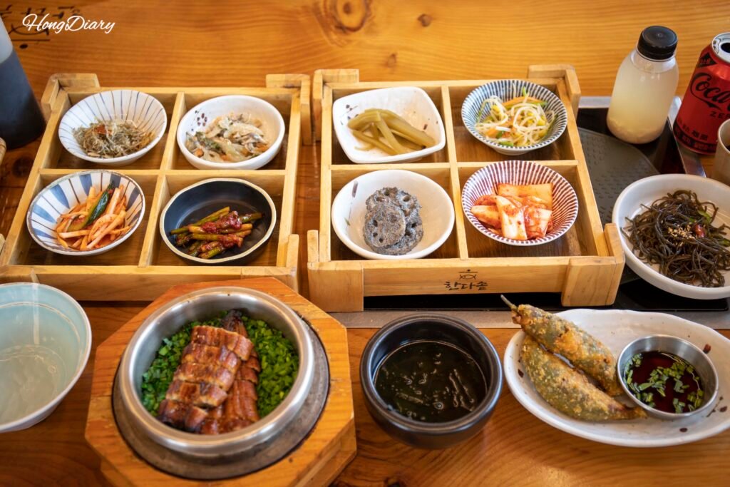 Full meal spread at Handassot Gyeongju including eel rice pot and stuffed chili fritters