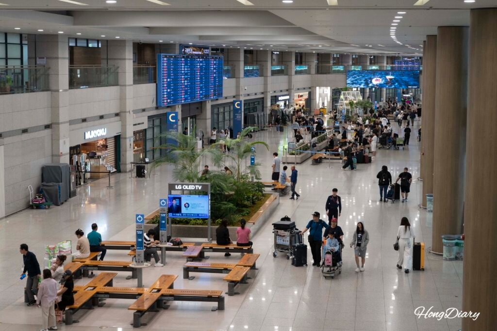 Interior del Aeropuerto Internacional de Incheon con señalización y pasajeros