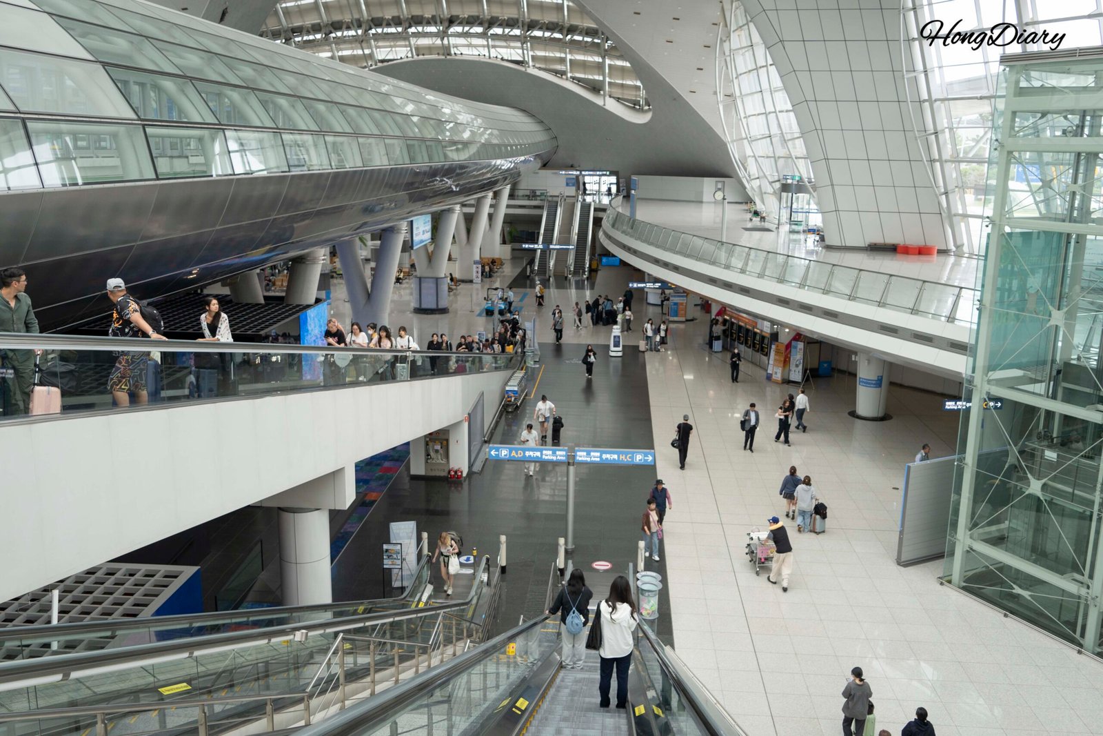 Interior of Incheon International Airport arrivals hall with passengers and signage