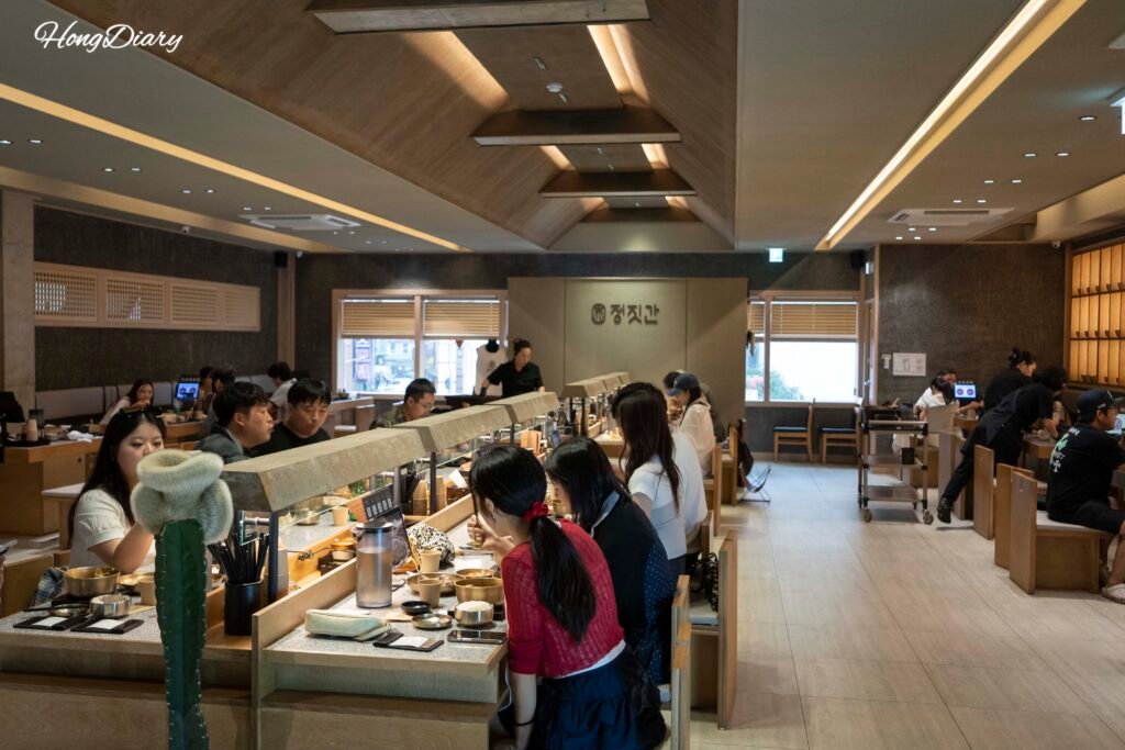 Second floor dining area inside Jeongjitgan Busan Station with tables and customers