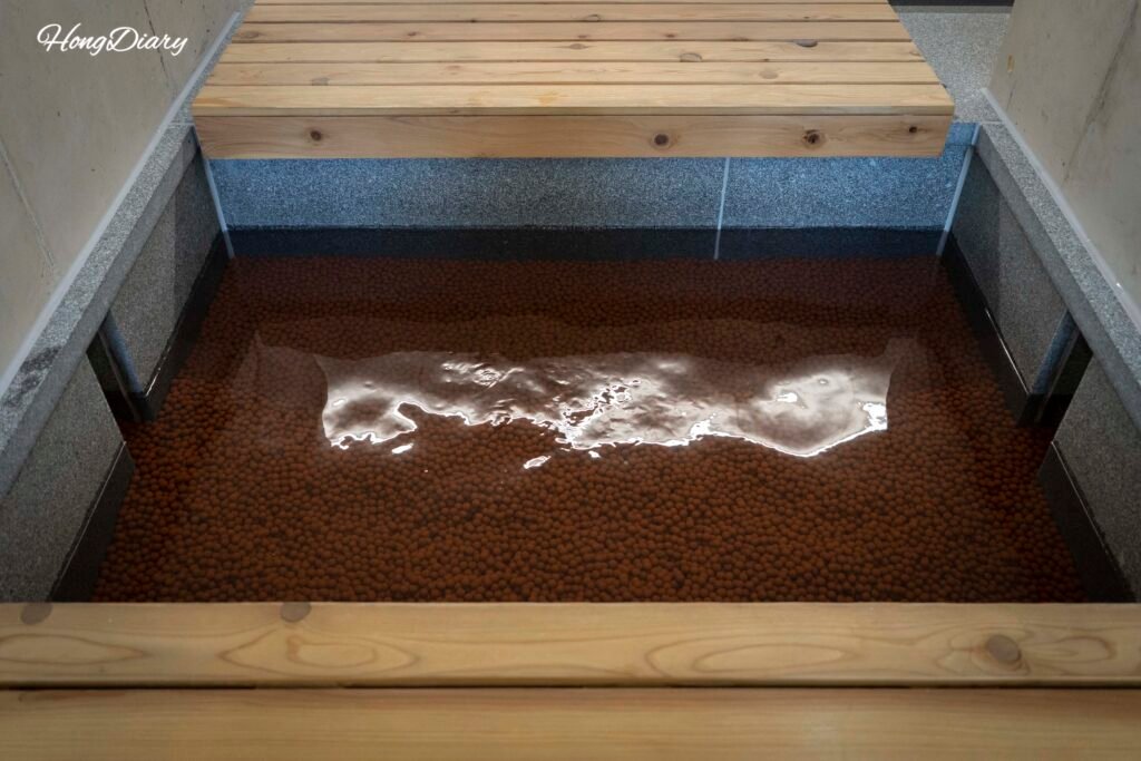 Healing foot spa zone at Rainbow Healing Center Yeongdong with stone wall view
