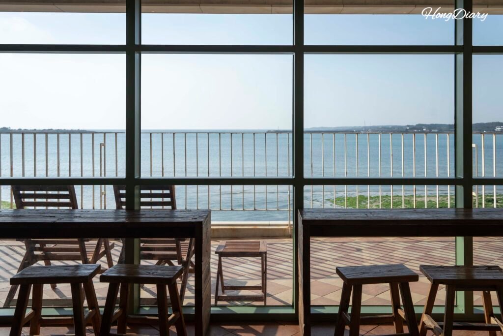 Asientos junto a la ventana panorámica con vista al mar en Seogwipean Bakery