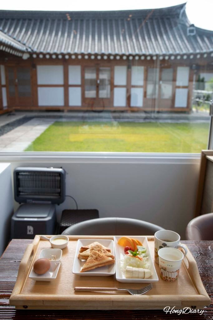 Desayuno gratis del alojamiento hanok Wonhwaru Gyeongju con sándwich fruta y huevo