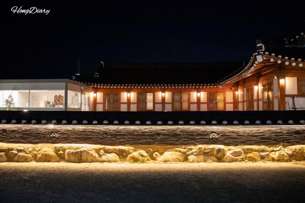 Wonhwaru Gyeongju hanok guesthouse lit up at night with traditional wooden eaves
