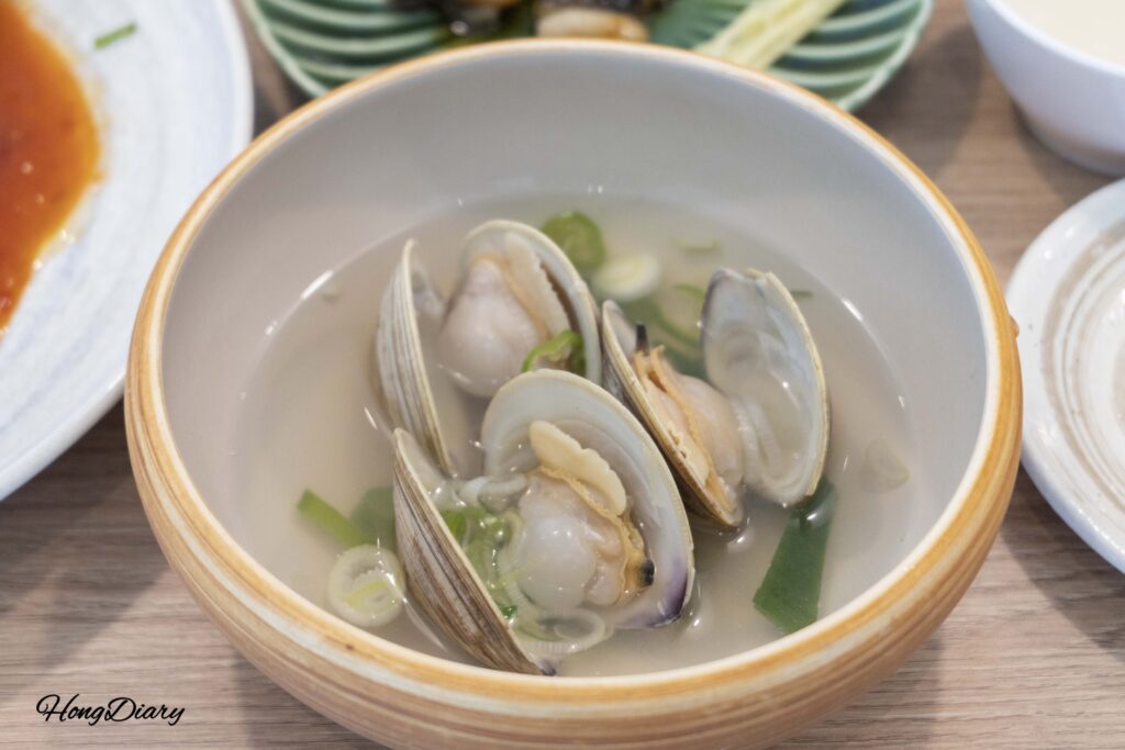 Plato con almejas y mariscos ya cocidos del shabu-shabu en Cosmos Busan BIFC2