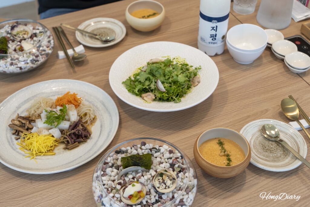 Amuse-bouche and welcome dishes at Cosmos Busan including carrot porridge, clam salad, and tangpyeongchae