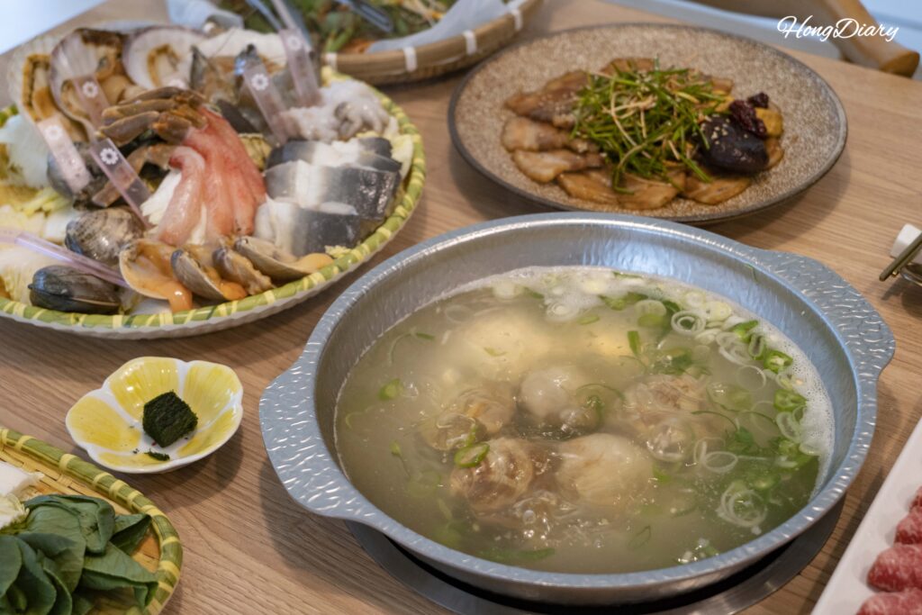 White clams simmering in clear broth at Cosmos Busan BIFC2 shabu-shabu