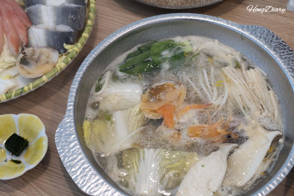 Galmi clams from Busan's Nakdong River estuary being cooked in shabu-shabu broth at Cosmos Busan