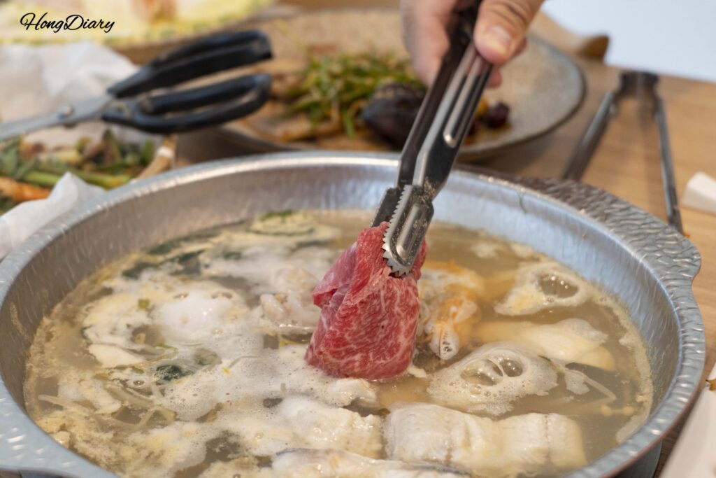 Thin slices of 1++ hanwoo beef being added to the shabu-shabu pot at Cosmos Busan BIFC2