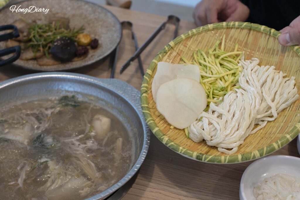 Kalguksu noodles cooking in the remaining seafood shabu broth at Cosmos Busan BIFC2
