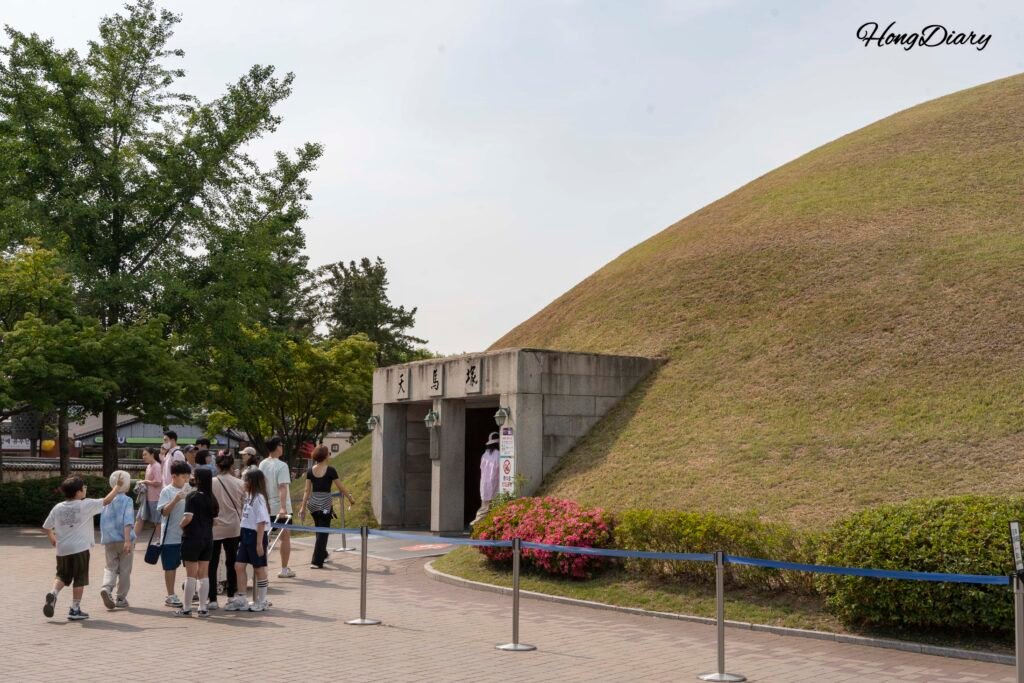 夕暮れの光に照らされた慶州・大陵苑の芝生に覆われた新羅時代の古墳群
