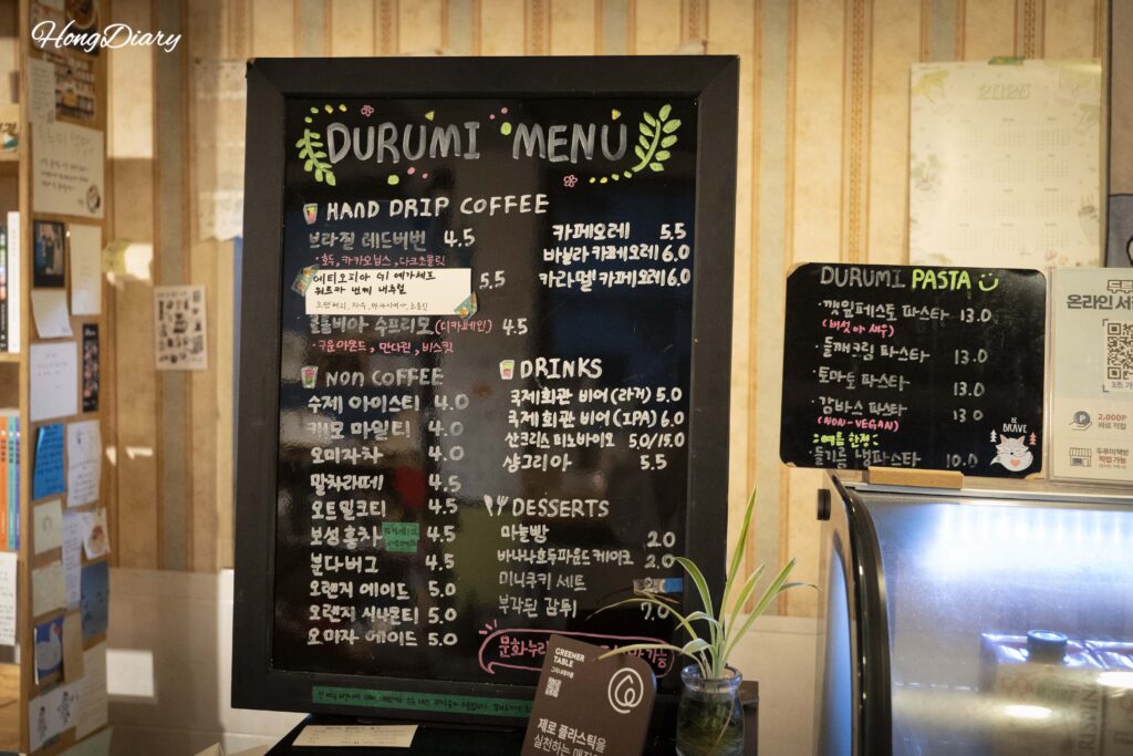 Hand-written menu board at Durumi Bookshop showing drinks, craft beer, and pasta