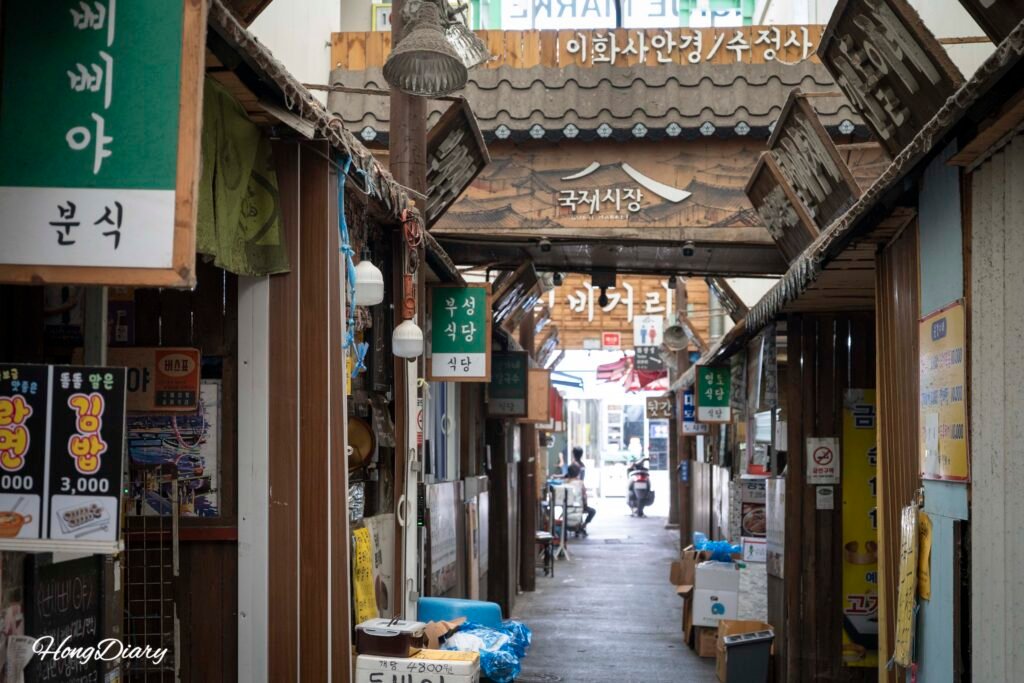 Street view inside Gukje Market with shoppers walking between stalls