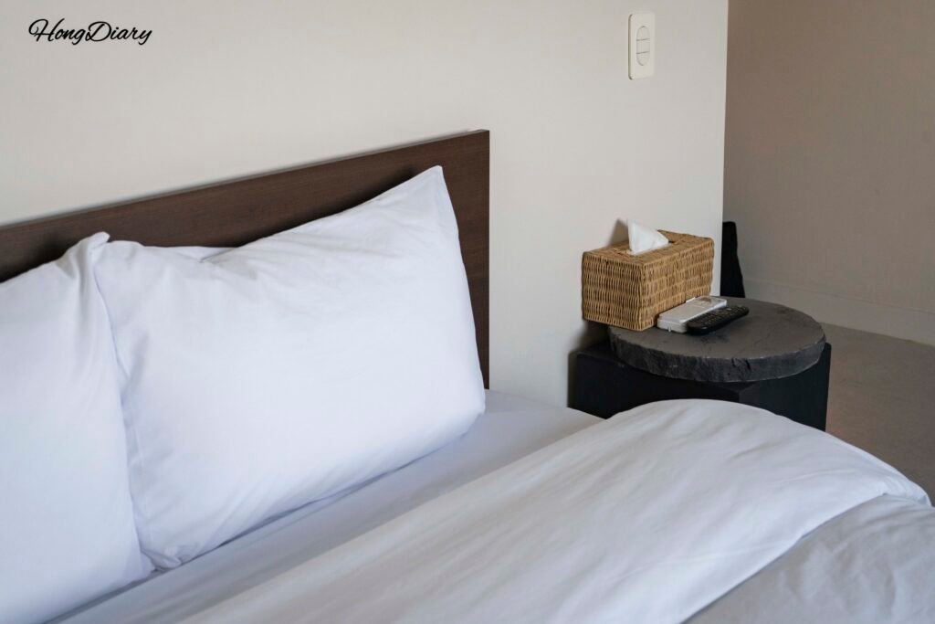 Comfortable double bed in Gwangalli W Hotel ocean view room with white bedding and ocean-facing window
