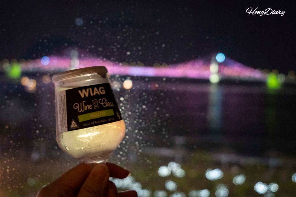 広安里Wホテルの客室からワイン越しに望む広安大橋の夜景