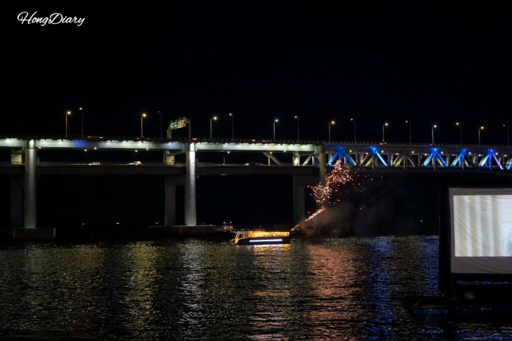 Puente Gwangan iluminado de noche con yates y fuegos artificiales sobre el agua en Gwangalli, Busán