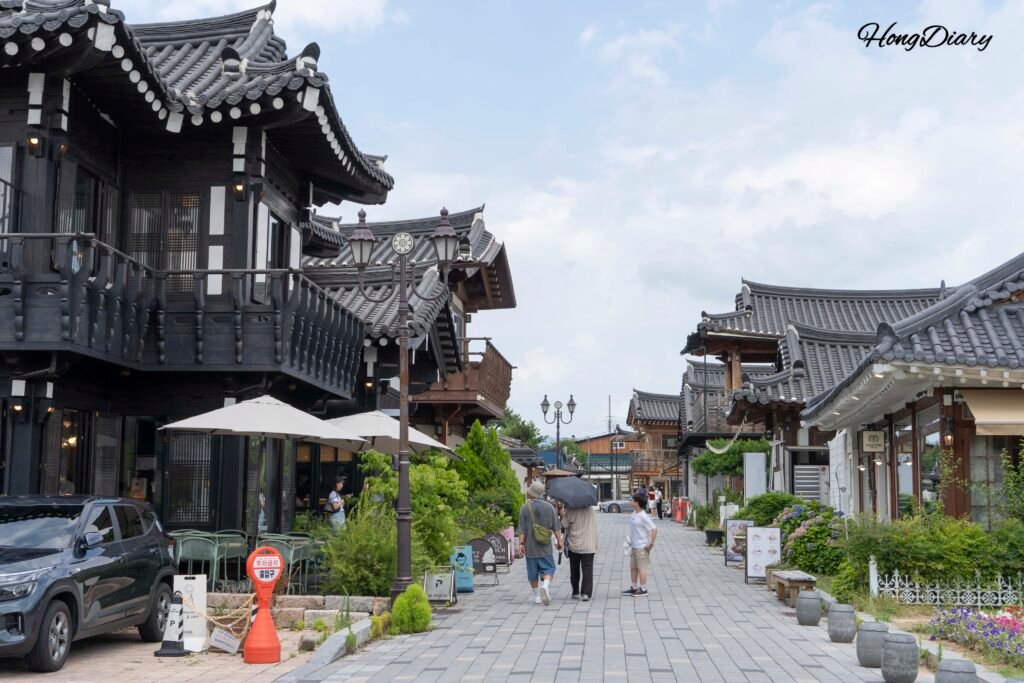 昼間の慶州・皇理団キルの通り。韓屋スタイルの店舗の前を歩く観光客