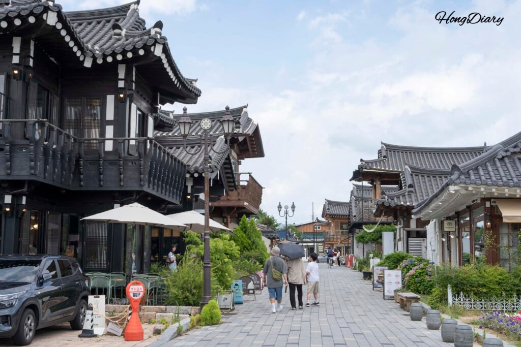 Daytime view of Hwangnidan-gil street in Gyeongju with visitors walking past hanok-style shops