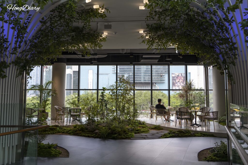 Jardín de musgo con plantas y ventanales de piso a techo en el segundo piso de BIFC2 Square Garden, Busan