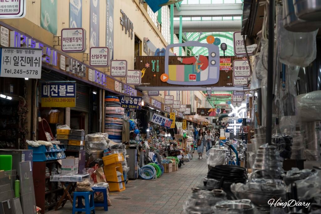 Callejón con puestos y compradores dentro del Mercado Gukje en Busan