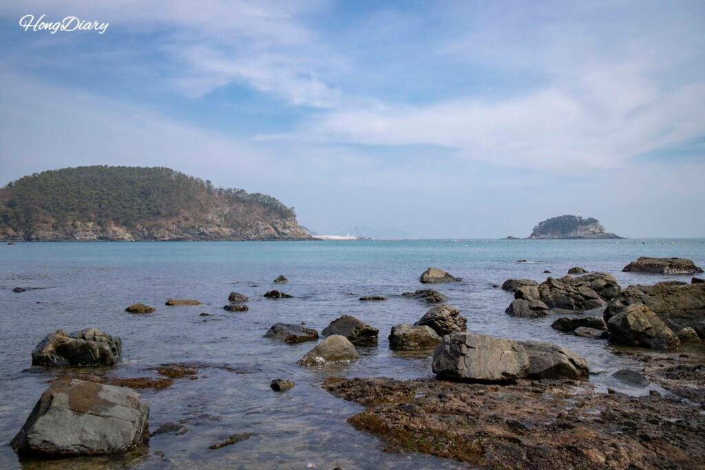 Playa escondida con agua cristalina entre acantilados rocosos en Molundae, Busán