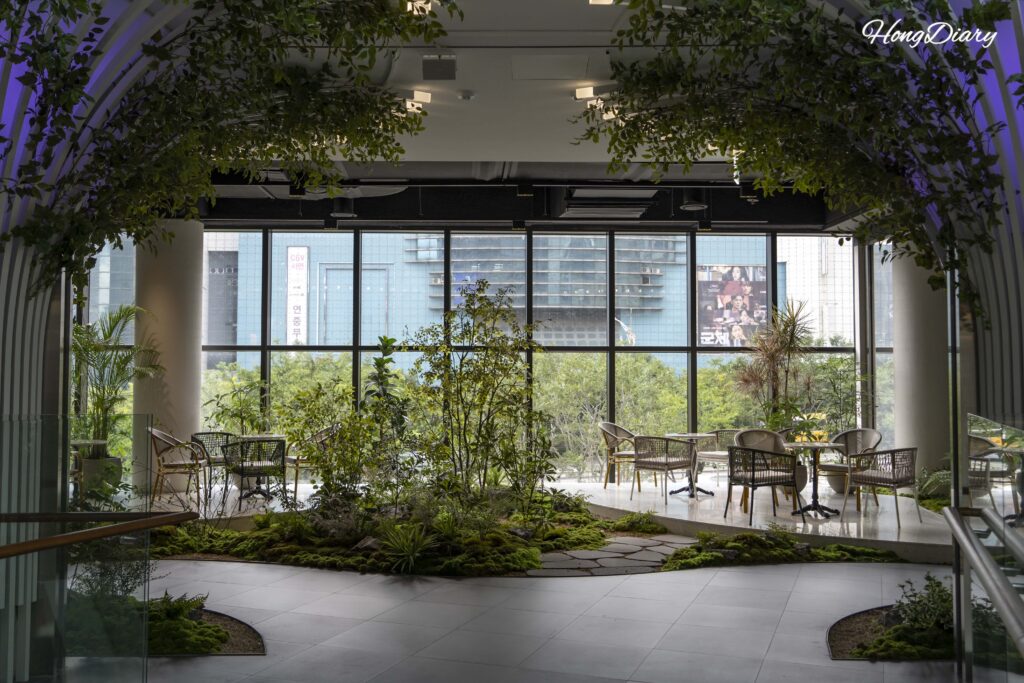 Moss garden rest area with green plants and floor-to-ceiling windows on the second floor of BIFC2 Square Garden, Busan