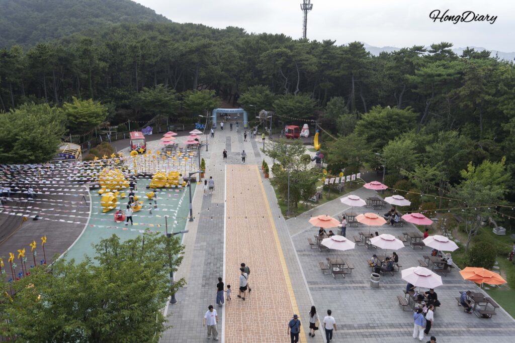 Plaza Park Square en Songdo Sky Park vista desde la azotea, con esculturas de dinosaurios y zonas de descanso, Busan
