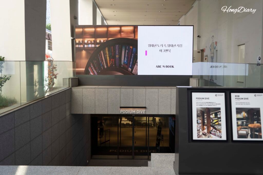 Escalera de entrada a Podium Dive en Gwangalli con pantalla digital como señalización