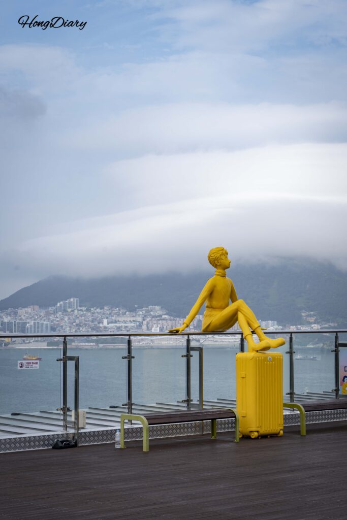 Escultura de viajero en el Mirador Sky Harbor, Songdo Sky Park, Busan