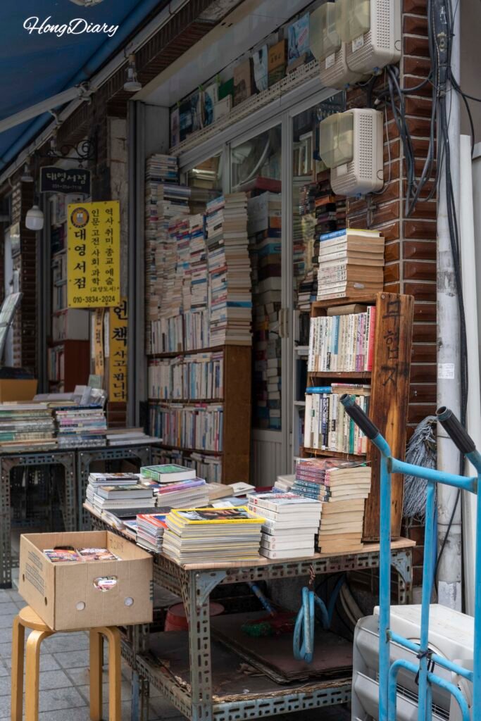 Books stacked from floor to ceiling inside a used bookshop at Bosu-dong Book Street