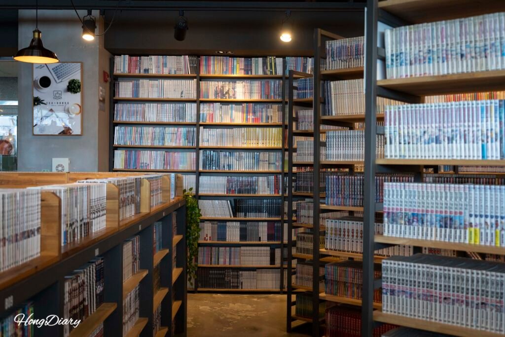 Estantes de libros dentro del café Tea & Books con vista al mar en Gwanganli
