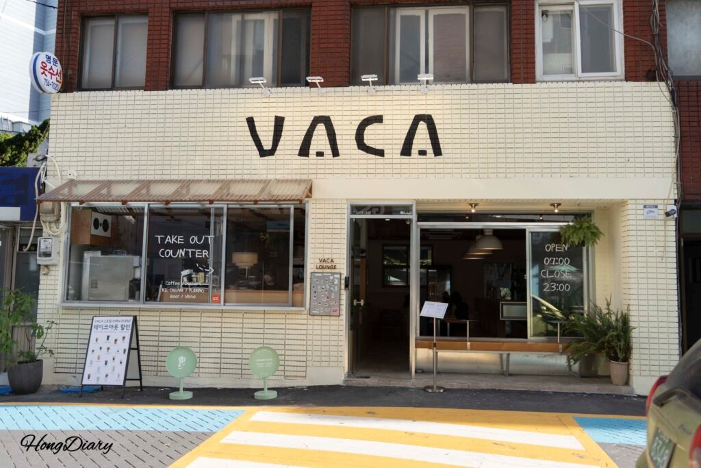 Exterior of VACA Coffee Lounge on a quiet side street in Suyeong-gu, one block from Gwangalli Beach, Busan