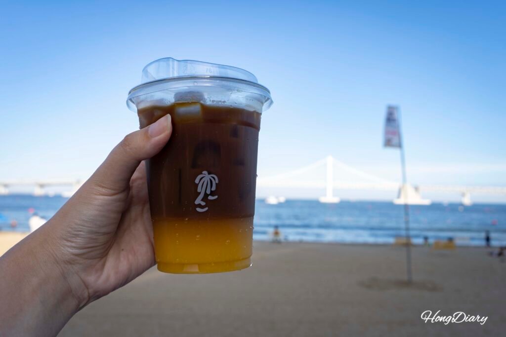 Vaso de takeout del Orange Americano, bebida signature de VACA Coffee Lounge Gwangalli