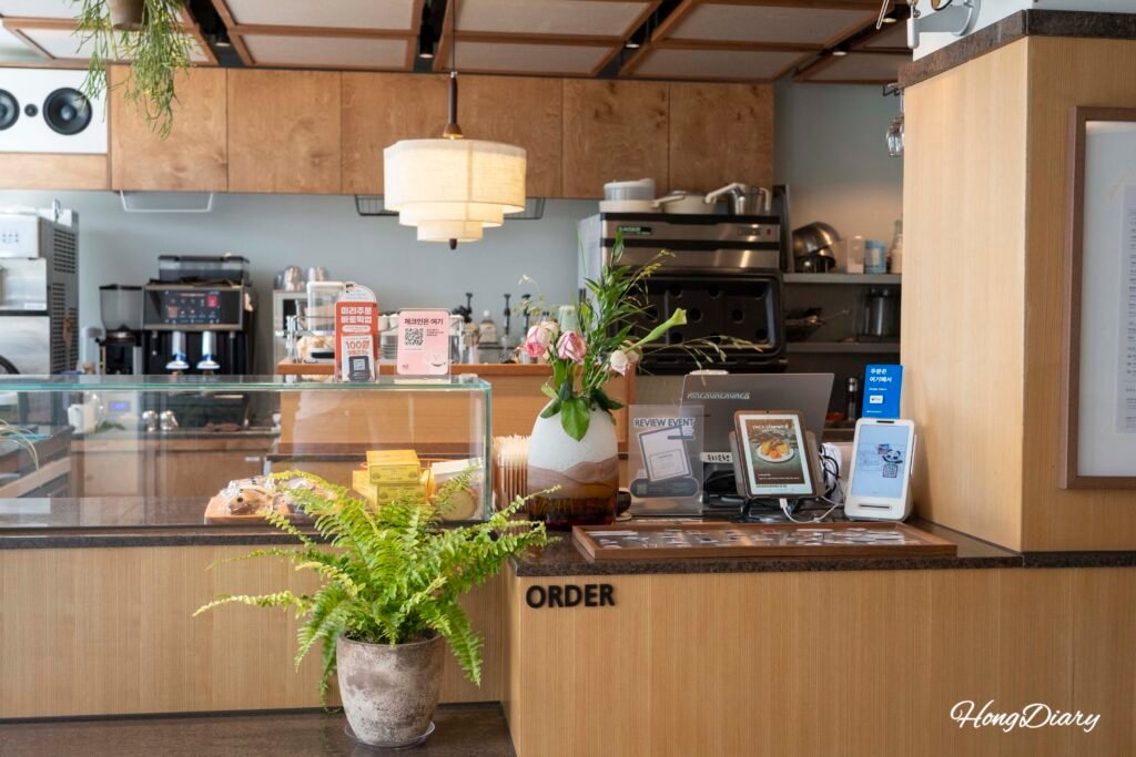 Order counter inside VACA Coffee Lounge Gwangalli with barista station and display