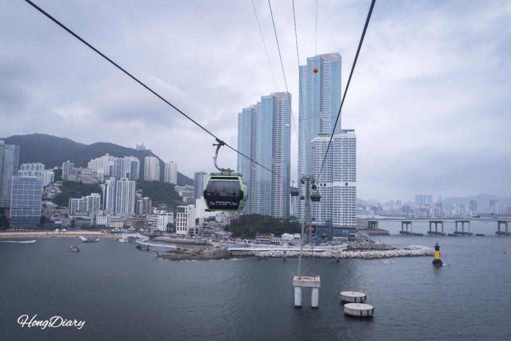 Vista panorámica de la playa de Songdo y el puente Namhang desde el interior del teleférico, Busan