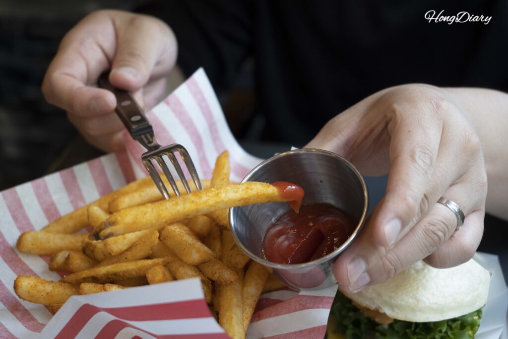 バオバーガーのシーズニング付きポテトフライをトマトケチャップにつける様子