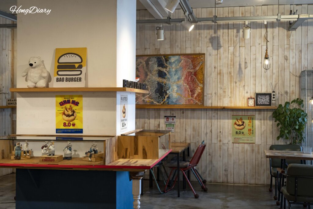 Interior of Bao Burger Songjeong showing warm wood decor and cozy seating in a converted Korean house