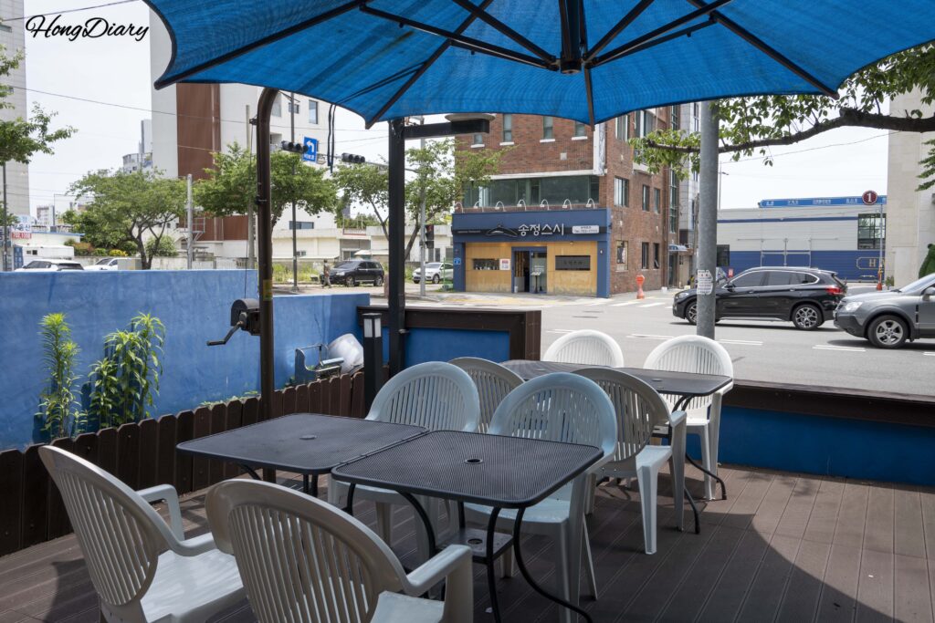 Outdoor terrace seating area at Bao Burger near Songjeong Beach in Busan