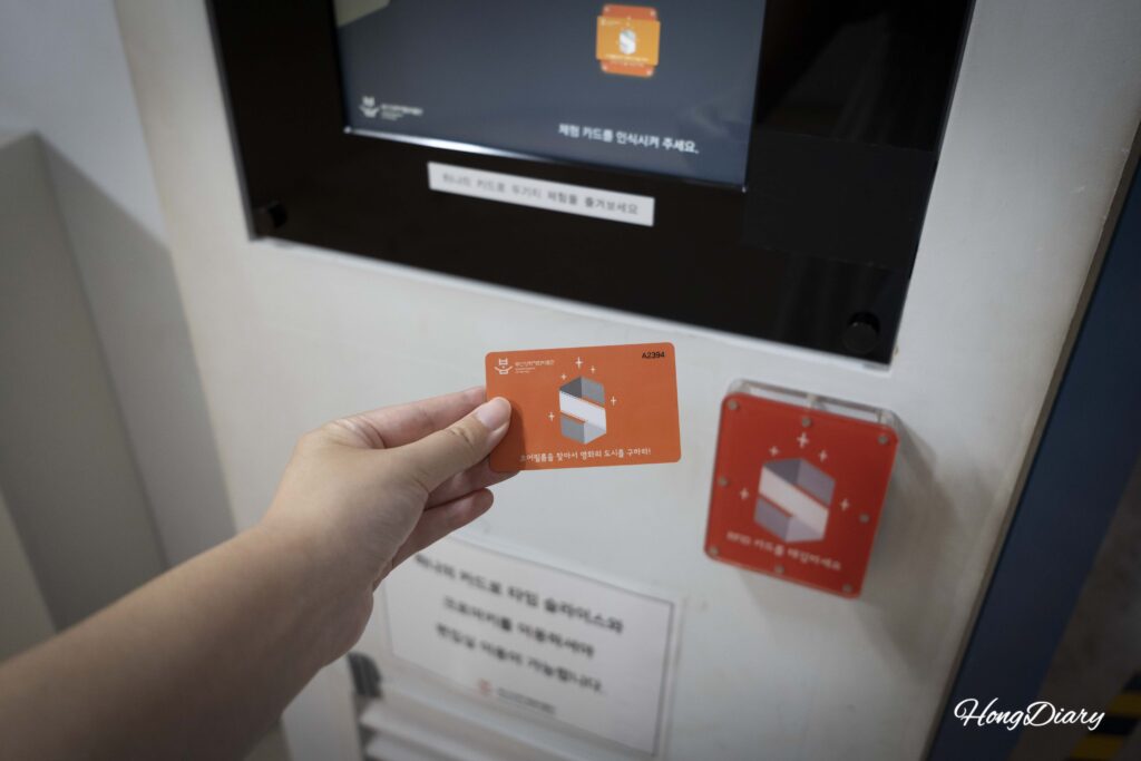 Visitor tapping RFID experience card at an orange reader station