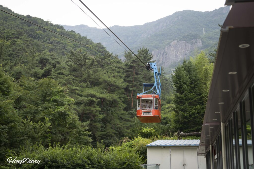 山から下りてくる金烏山ケーブルカー。谷と亀尾の街並みが背景に見える