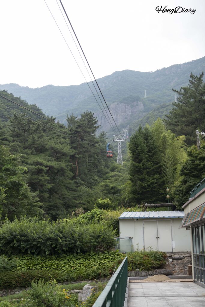 Wide view of the Geumosan cable car descending the mountain with the valley and Gumi city visible below