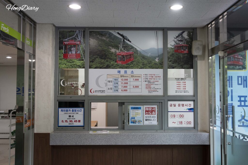 金烏山ケーブルカーの券売所と料金表示板。大人・小人の片道・往復料金が記載