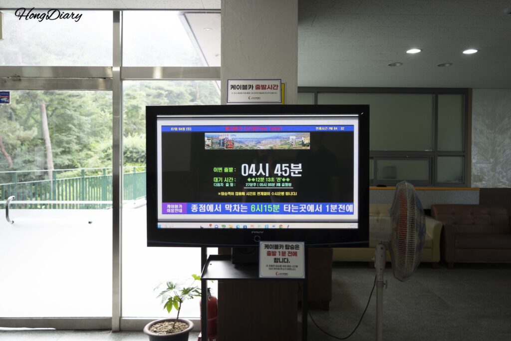 Waiting room inside the Geumosan cable car station with a departure time display